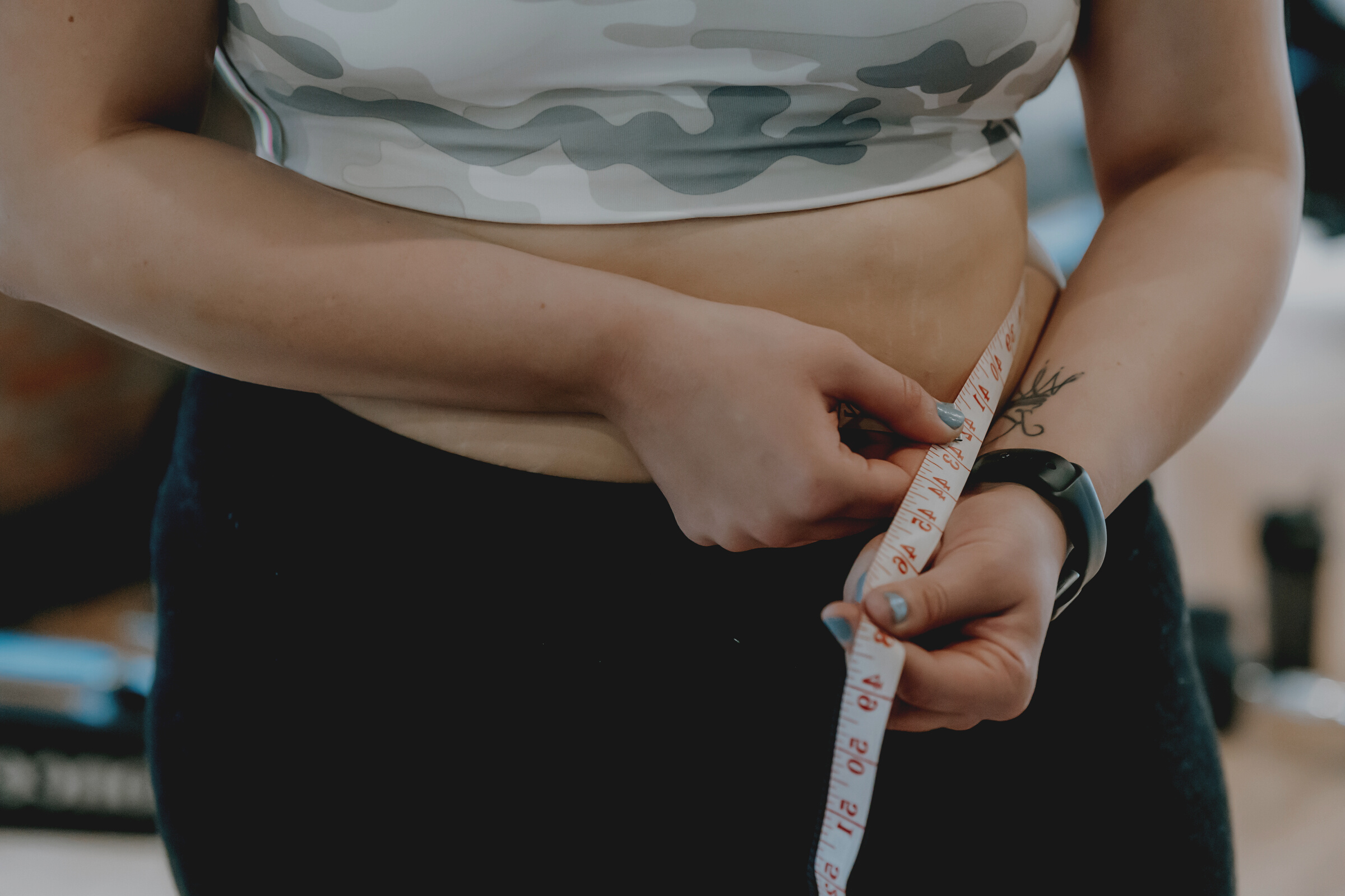 Plump woman in sportswear with measuring tape