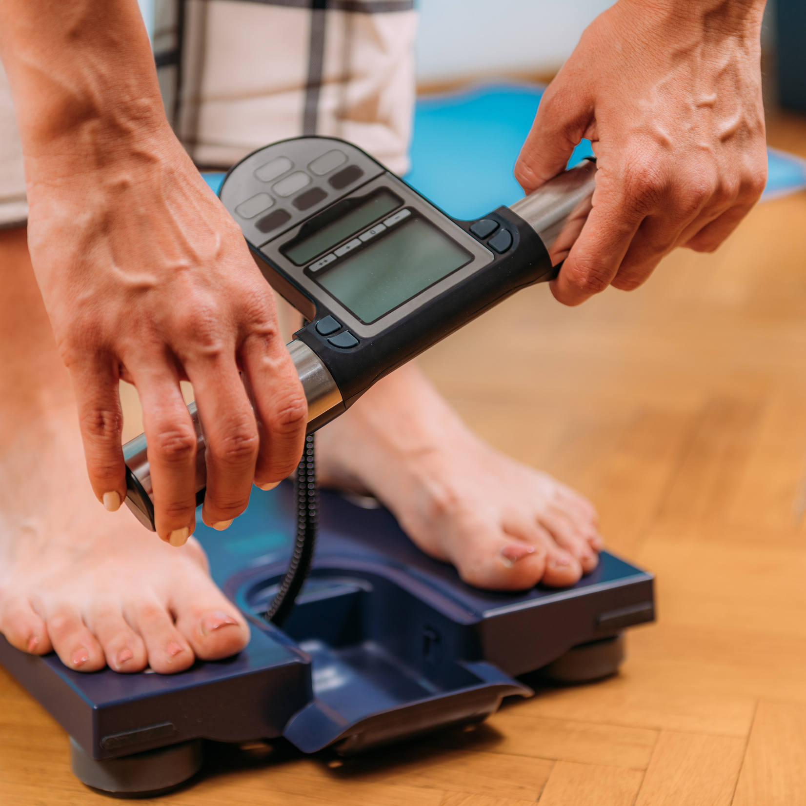 Woman Measuring Body Fat with Body Composition Monitor